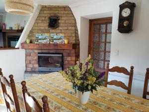 a dining room table with a vase of flowers on it at La petite Ginette in Serres +16 photos