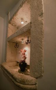 a plant in a vase sitting on a stone ledge at Apartments Villa Cardo in Mali Ston