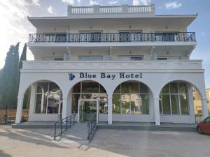 a white building with a blue bay hotel at Blue Bay Hotel in Iraklitsa