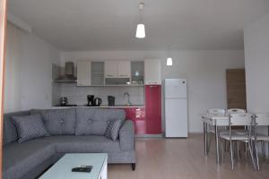a living room with a couch and a kitchen at Çeşme Suites in Çeşme