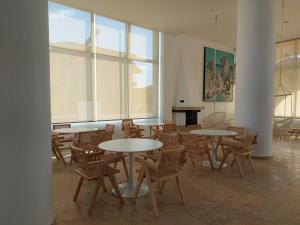a room with tables and chairs and a piano at Blue Bay Hotel in Iraklitsa
