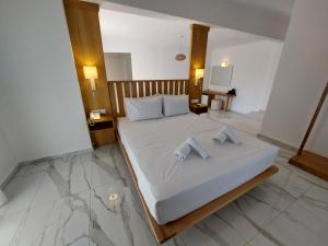 a bedroom with a bed with two towels on it at Blue Bay Hotel in Iraklitsa