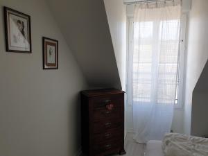 - une chambre avec une commode et une fenêtre dans l'établissement bel appartement 4 personnes, à Port-en-Bessin-Huppain