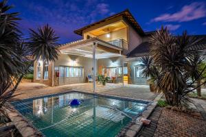 a house with a swimming pool in front of it at Blue Rain Guest House in Bloemfontein