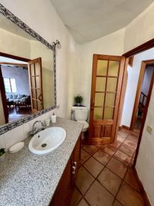 ein Badezimmer mit Waschbecken, Toilette und Spiegel in der Unterkunft Casa Rural Las Guindas - Cozy Rural House, Hierro in Erese