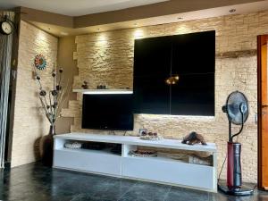 a living room with a large television on a brick wall at Vista mare La Maddalena con posto Barca e posto Auto coperto in La Maddalena