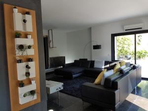 a living room with a black couch and a table at Menerbes Luberon maison moderne clim piscine in Ménerbes