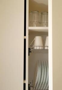 eine offene Kühlschranktür mit Gläsern und Besteck in der Unterkunft Butukas Nidai in Nida + 10 Fotos