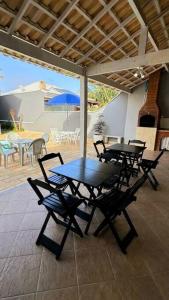 a table and chairs on a patio with an umbrella at Praia seca Paraíso in Araruama