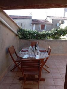 een houten tafel met 2 stoelen en een fles wijn bij Duplex La Terrasse Jasmin in Mèze +42 foto's