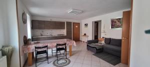 een keuken en woonkamer met een tafel en een bank bij Stefy House in Pontebba