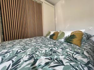 a bedroom with a bed with a green and white comforter at Castle - Vue sur le château - Hypercentre in Caen