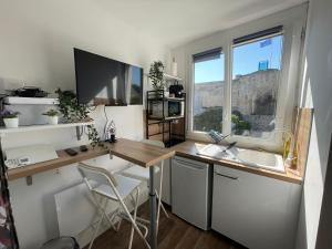a kitchen with a desk and a sink and a window at Castle - Vue sur le château - Hypercentre in Caen