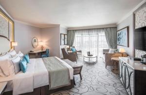 a hotel room with a large bed and a living room at Labourdonnais Waterfront Hotel in Port Louis