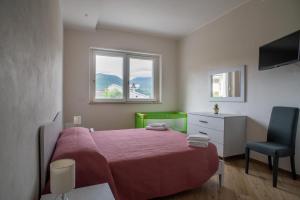 a bedroom with a bed and a chair and two windows at Casa Gioia - Natura & Relax in Viggianello