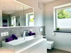ein Badezimmer mit einem weißen Waschbecken und einem Spiegel in der Unterkunft Ferienwohnung Hoffmann-Schiffer in Bischofswiesen + 42 Fotos