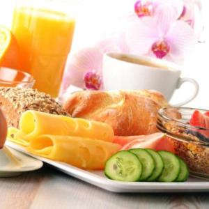a plate of food with bread and vegetables and a cup of coffee at Georgi Schloss - Boutique Hotel in Ehrenhausen