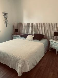 a bedroom with a large bed and two night tables at Villa bois avec piscine in Arès +13 photos