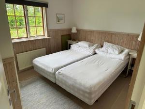 a bedroom with a bed with white sheets and pillows at Charmiga Norrangen in Väddö
