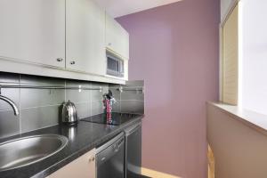eine Küche mit Spüle und Arbeitsplatte in der Unterkunft GuestReady - Apt moderne Paris La Défense avec AC in La Défense