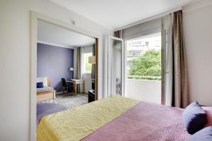 ein Schlafzimmer mit einem Bett, einem Fenster und einem Schreibtisch in der Unterkunft GuestReady - Apt moderne Paris La Défense avec AC in La Défense