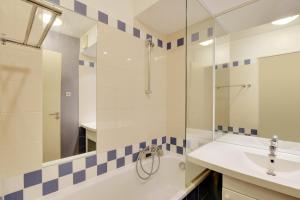 ein Badezimmer mit Waschbecken und Dusche in der Unterkunft GuestReady - Apt moderne Paris La Défense avec AC in La Défense