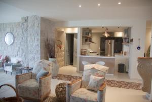 a living room with two chairs and a kitchen at Beit Teta Mona in Al ‘Arabah