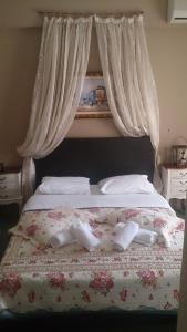 a bed with two white towels and flowers on it at Hotel Villa Tasko in Drama