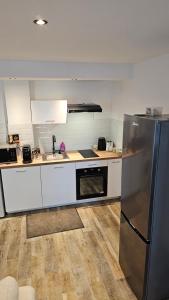 une cuisine avec un réfrigérateur en acier inoxydable et un évier dans l'établissement Magnifique appartement à Bezons, à Bezons