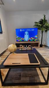 un salon avec une table et une télévision dans l'établissement Magnifique appartement à Bezons, à Bezons