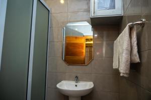 une salle de bain avec un lavabo et un miroir dans l'établissement Agape Villa, à Sékondi