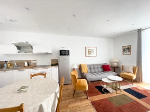 a living room with a couch and a table at Le 58 Bayeux bel apt bien équipé centre ville parking gratuit à proximité in Bayeux