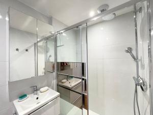 a white bathroom with a shower and a sink at Le 58 Bayeux bel apt bien équipé centre ville parking gratuit à proximité in Bayeux +17 photos