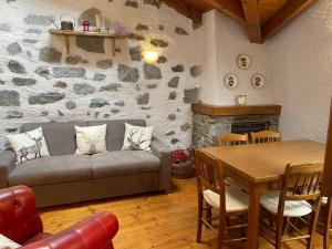 a living room with a couch and a table at Cristian Castello - La Poltrona Rossa in Ponte di Legno