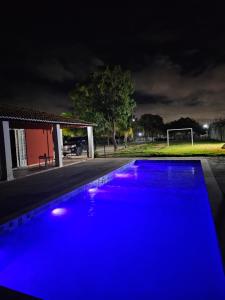 een blauw zwembad dat 's nachts verlicht wordt bij Chácara Urbana in Juazeiro