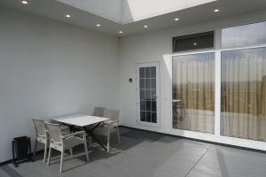 a dining room with a table and chairs and a large window at Домик 2 Kok Tobe Village in Almaty