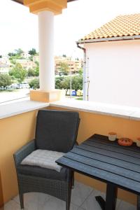 a chair sitting next to a table and a window at Sunce in Mali Lošinj