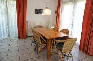 a dining room with a wooden table and chairs at Kustverhuur, Park Scheldeveste Zwin 015, met grote omheinde tuin in Breskens