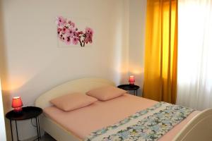 Un dormitorio con una cama con dos almohadas rosas. en Sunce, en Mali Lošinj
