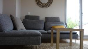ein Wohnzimmer mit Couch und Tisch in der Unterkunft Chez Caroline in Rainneville