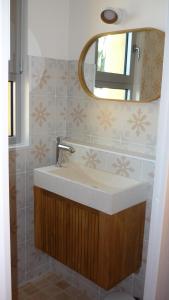ein Badezimmer mit Waschbecken und Spiegel in der Unterkunft Chez Caroline in Rainneville