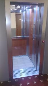 ascensor de cristal en una habitación con espejo en Hotel Villa Tasko, en Drama