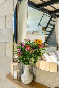eine Vase mit Blumen auf einem Tisch vor einem Spiegel in der Unterkunft Casa KiKi Penthouse by Beach and Town in San José del Cabo