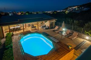 a swimming pool in a backyard at night at Atalaya Villa in Stalís