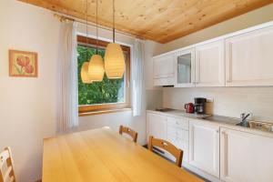 a kitchen with a wooden table and a window at Silbernagl - Monolokal mit Ausblick in Issengo +15 photos