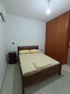 a bedroom with a bed and a wooden cabinet at Giannis's Apartments in Chios