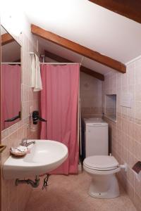 a bathroom with a pink shower curtain and a toilet at Casa Vacanza Gialu in Erchie +64 photos