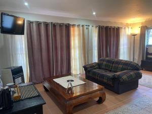 a living room with a couch and a coffee table at Pringle Studio in Benoni +1 photo