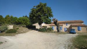 une voiture est garée devant une maison dans l'établissement Chambres d'hôtes L'Amphitryon 5 CHAMBRES, à Villemus