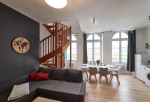 un salon avec un canapé et une table avec des chaises dans l'établissement L'Éclat Travot Central Lumineux Vue Sublime, à Cholet